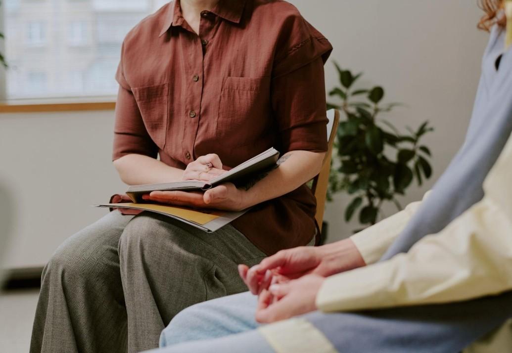 Two people seated together in a reflective workshop conversation